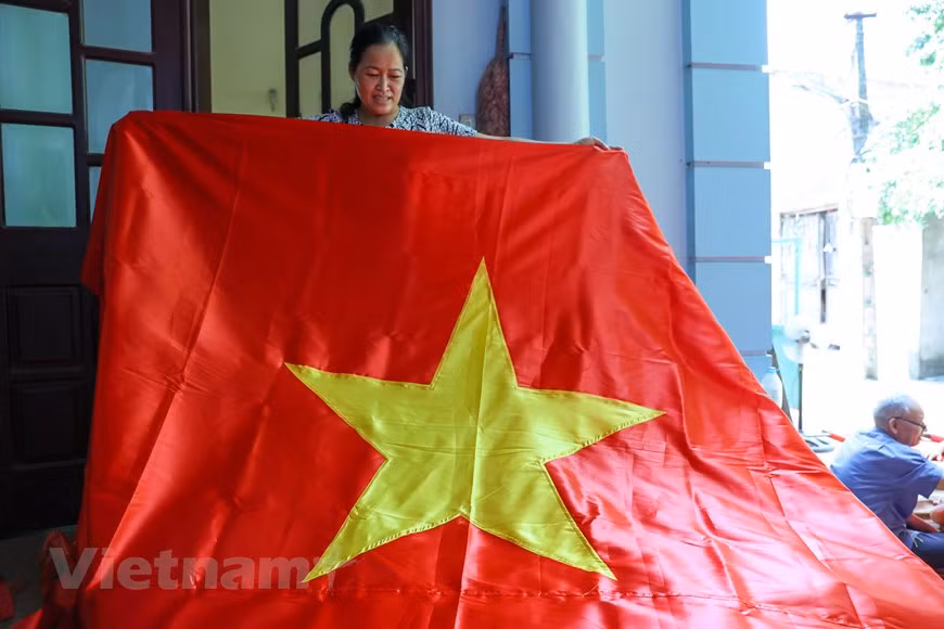 According to veteran embroider Vuong Thi Nhung, whose family has three generations practicing the craft, sewing is much simpler than embroidering a flag. In a day, hundreds of flags can be made using sewing machines, while it takes weeks for embroiderers to achieve the same volume. Embroidering a flag is a painstaking and time-consuming process that undergoes several steps such as choosing, measuring, and cutting fabrics, and embroidering the five pointed golden star, among others. Each step requires a lot of efforts and meticulousness from the makers. Most flags are now made with embroidery machines. But the craft ones possess their own beauty and value and their makers take pride and honour of their work. (Photo: VietnamPlus)