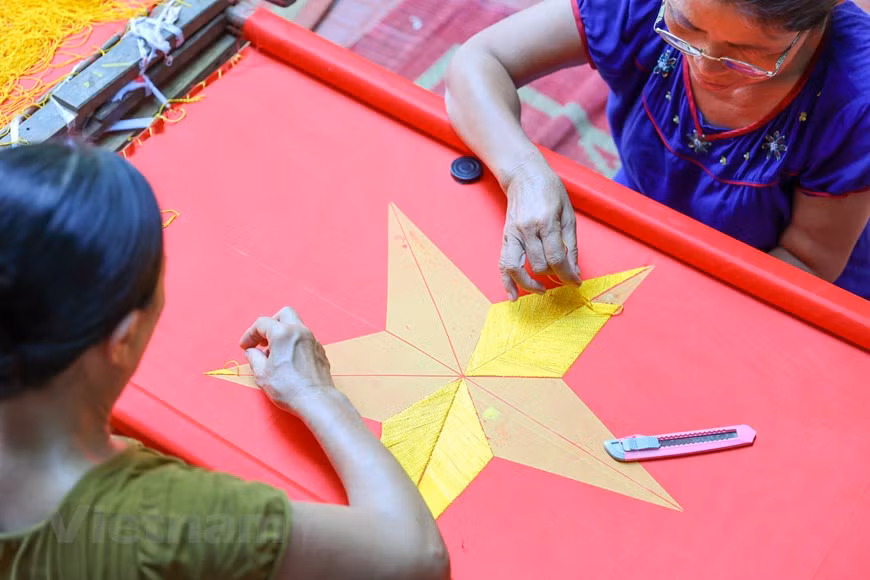 As a result of a painstaking and time-consuming process, each embroidered flags is sold at a price of at least 300,000 VND (12.94 USD). Embroidering the national flag is a demanding job that requires a lot of finesses and meticulousness in every stitch, as the final products are for important events. For a veteran embroiderer, it often takes between 3 and 5 days to complete an embroidered flag. For amateurs, it might take up to a week. Embroidering the five-pointed golden star in the middle of the flag is the hardest as it’s not easy to make the wings symmetrical. (Photo: VietnamPlus)