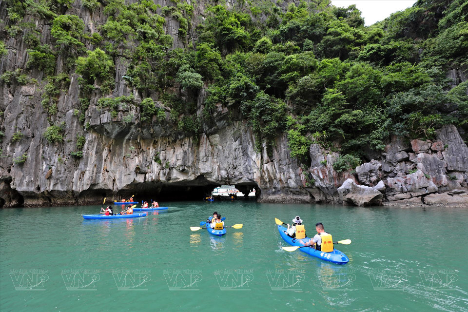 Tourists paddle kayaks and explore caves on Ha Long Bay. (Photo: VNP/VNA)