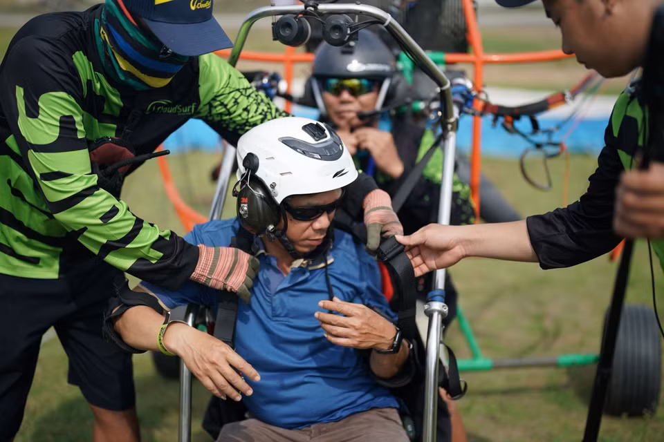 Pilots and technicians help visitors don protective gear and instruct them on safety measures. (Photo: Tin tuc Newspaper)