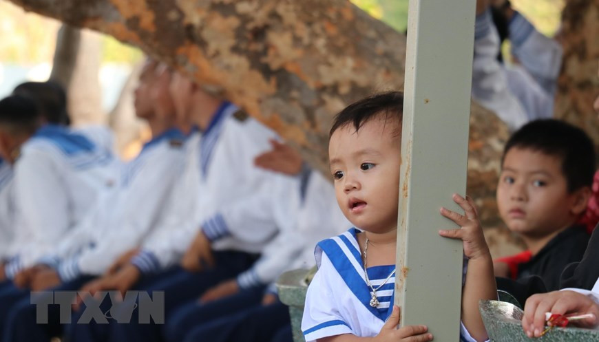 Lam Nhat Kien Huy enjoys an art performance staged by soldiers on Truong Sa Lon island. (Photo: VNA)