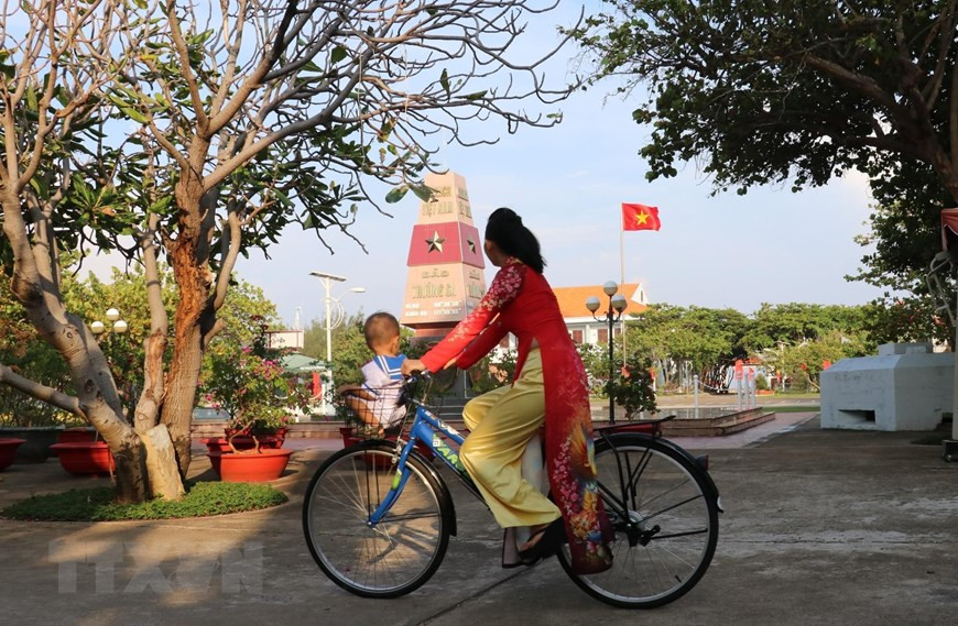 Eighteen-month old Lam Nhat Kien Huy and his mother, Nguyen Thi Phuong Dung, pass a territorial mark on Truong Sa Lon island. (Photo: VNA)