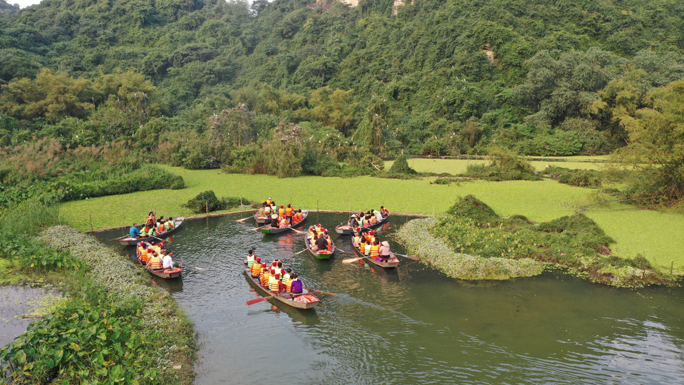 Tourists take a boat to Thung Nang (Sunshine Valley). Thung Nang is a low-lying place, flooded and surrounded by majestic high mountains, separated from the noisy life rhythm. (Photo: VNA)