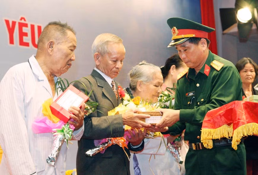 Colonel Nguyen Min, Deputy Commander of the Da Nang City Military Command, presents gifts to the relatives of martyrs who died in Gac Ma battle in 1988, at the ‘Towards the beloved Truong Sa’ exchange programme, March 14, 2013. (Photo: VNA)