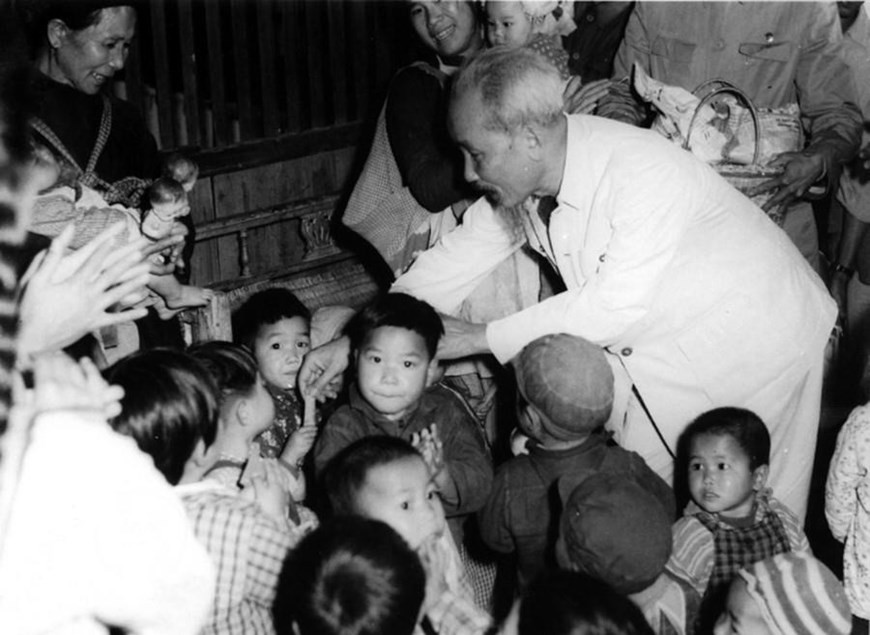 President Ho Chi Minh gives candies to children of workers at Du Phong Pottery Factory and Soay Nguon Agricultural Cooperative in Mong Cai town (now Mong Cai city, Quang Ninh province). (Photo: Archives/VNA)