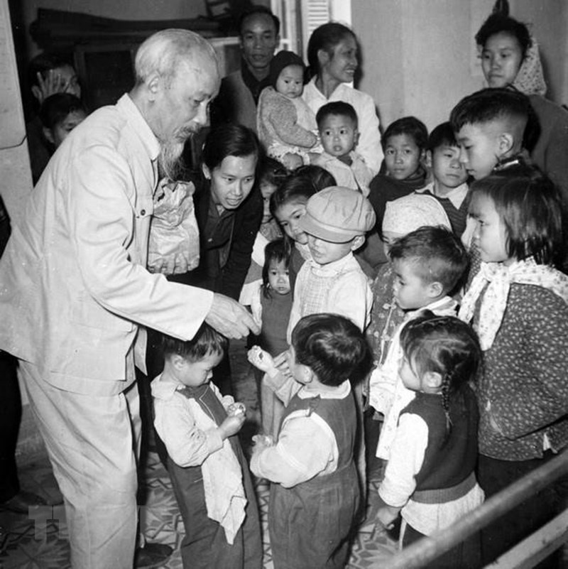 President Ho Chi Minh gives candies to kids at the kindergarten for children of workers of Sao Vang Rubber Factory, Hanoi Soap Co. and Thang Long Tobacco Co., February 15, 1961. (Photo: Archives/VNA)
