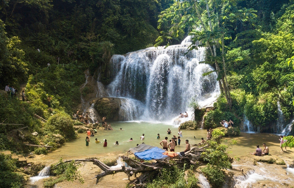 Tourists having fun downstream of Mu Waterfall. (Photo: VNA)