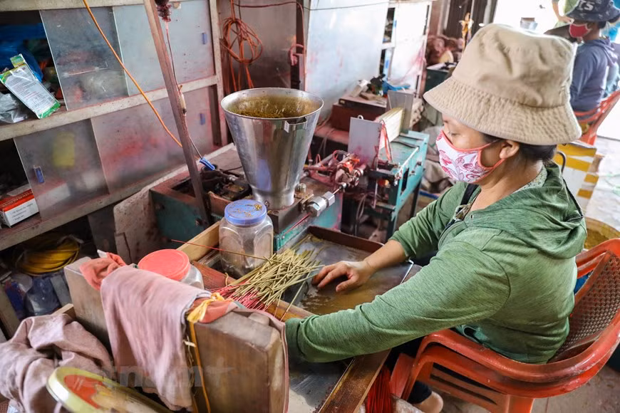 Villagers in Quang Phu Cau are busy with producing incense all year round, but they are busiest in the year-end months to ready supply for the Lunar New Year, the biggest traditional festival in Vietnam. The making of incense includes various steps, each one done by hand, including splitting bamboo into thin sticks, dyeing them red, letting them dry outdoors, mixing aromatic paste, and rolling the paste around the sticks, and drying them in the sun again. However, the application of machinery has helped ease the burden on local workers. Incense sticks produced in Quang Phu Cau are not only favoured by domestic customers but also exported to many foreign markets around the world. (Photo: VietnamPlus)