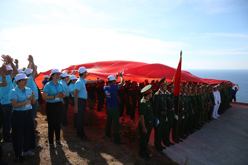 Following the flag raising ceremony, the national flag is taken down and spread out to cover the area where the event is hosted. The 250-square metre flag spreading ceremony took place at the base of the flag pole, which was an important ceremony to honour the image of the country, affirm the national sovereignty over the two archipelagos of Hoang Sa (Paracel) and Truong Sa (Spratly) of Vietnam. The flag pole, which is 20 metres in height and looking towards Hoang Sa (Paracel) archipelago, was designed and built with funds raised by students as part of their “Students with the nation’s sea and islands 2013” programme. (Photo: VietnamPlus)