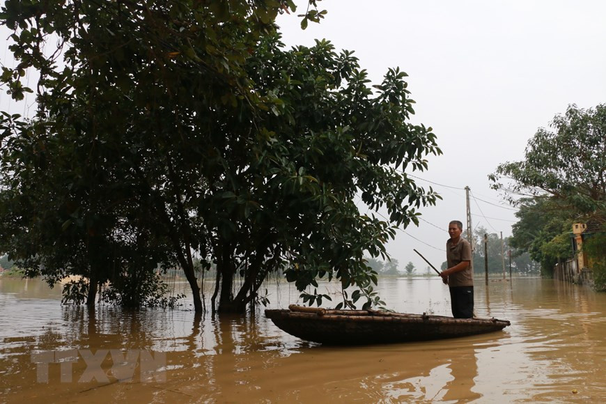 Rising water all the way makes it hard for people’s travel (Photo: VNA)