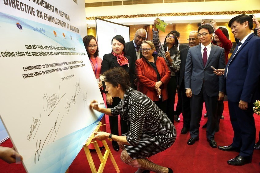 Vietnam is committed to further promoting the implementation of the Sustainable Development Goals, focusing on policies for sustainable poverty reduction, narrowing the development gap between geographic areas and population groups, especially vulnerable groups. In photo: Delegates sign to show commitment in response to the launch of the Scaling Up Nutrition Movement, jointly organised by the Ministry of Health and the United Nations Children's Fund. (Photo: VNA)