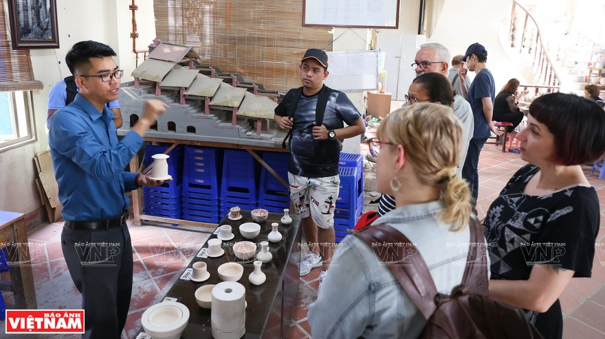 Foreign visitors learn about the history and culture of the pottery village (Photo: VNP/VNA)