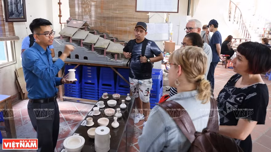 Foreign visitors learn about the history and culture of the pottery village (Photo: VNP/VNA)