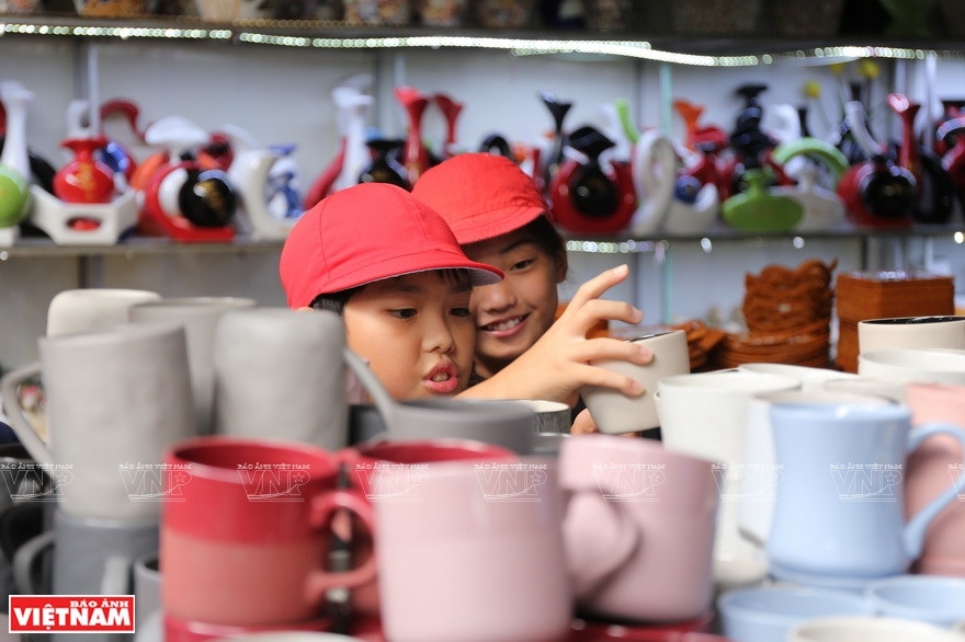 Two Japanese children select cute pottery cups during their picnic at Bat Trang pottery market (Photo: VNA)