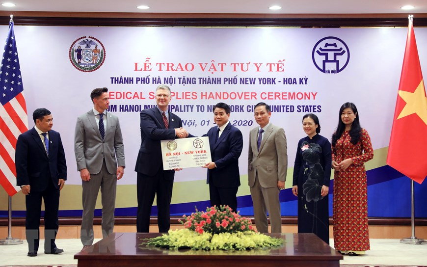 Chairman of the Hanoi People’s Committee Nguyen Duc Chung presents the token of medical supplies as gifts from the Vietnamese Government and people to US Ambassador to Vietnam Daniel J. Kritenbrink (Photo: VNA)