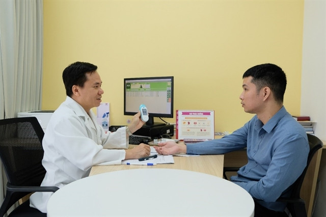 Doctor Nguyen Van Mui examines a patient at the Hanoi French Hospital. (Photo courtesy of HFH)