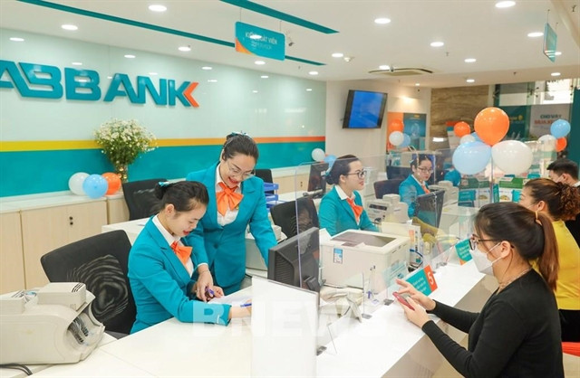 Customers make transaction at an ABBank office. The draft circular requires banks to carry out annual security and confidentiality inspections and assessments of the online banking system. (Photo: cafef.vn)