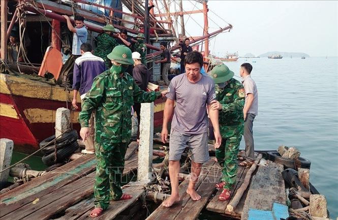 Border guards of Quang Binh province bring the saved fishermen to the mainland. (Source: VNA)