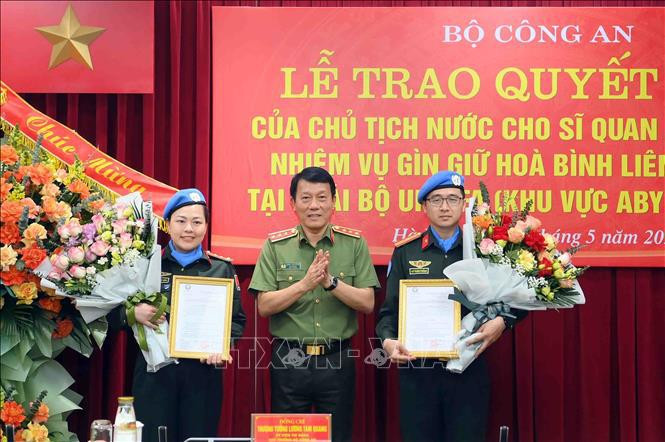 Deputy Minister of Public Security Sen. Lt. Gen. Luong Tam Quang (centre) presents the State President's decisions to the two officers on May 29. (Photo: VNA)