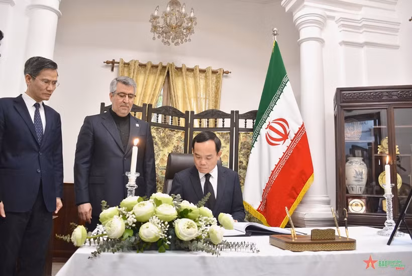 Deputy PM Tran Luu Quang writes in the condolence book at the Iranian Embassy in Hanoi on May 23. (Photo: qdnd.vn)