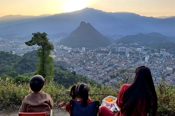 Tourists view the sunset over Ha Giang city from the Mo Neo Mountain. (Photo: VNA)