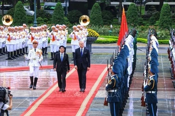 Vietnamese State President Luong Cuong (L) and Lithuanian President Gitanas Nauseda review the guard of honour at the welcome ceremony in Hanoi on June 12 morning. (Photo: VNA)