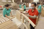 Workers make wooden furniture for export to the US, UK and EU markets at the factory of the Thiet Dan Two-Member Company Limited. (Photo: VNA)