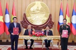 Vietnamese Party General Secretary To Lam (second, left), and Party General Secretary and President of Laos Thongloun Sisoulith witness the exchange of memorandum of understanding (MoU) on cooperation between the Vietnamese Ministry of Public Security and the Lao Ministry of National Defence on building a Vietnam - Laos friendship road. (Photo: VNA)