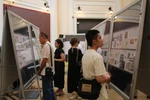 Delegates look at stamp collections at the exhibition. (Photo: VNA)