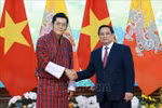 Prime Minister Pham Minh Chinh (R) welcomes King of Bhutan Jigme Khesar Namgyel Wangchuck in Hanoi on August 19. (Photo: VNA)