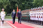 State President Luong Cuong (left) and French President Emmanuel Macron review the Guard of Honour of the Vietnam People’s Army. (Photo: VNA)