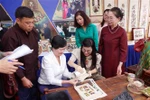 The spouse of Prime Minister Pham Minh Chinh, Le Thi Bich Tran, and delegates make Dong Ho folk paintings during their visit to Bac Ninh on April 21. (Photo: VNA)