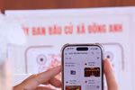 A voter scans a QR code with their smartphones to quickly check information related to their voting rights. (Photo: VNA)