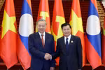 Party General Secretary To Lam (L) meets with LPRP General Secretary and President of Laos Thongloun Sisoulith during the visit. (Photo: VNA)