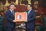 Prime Minister Pham Minh Chinh (R) and acting head of Samsung Electronics' Device Experience Division Roh Tae Moon. (Photo: VNA)