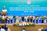 Prime Minister Pham Minh Chinh presents flowers to outstanding young people. (Photo: VNA)