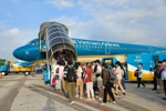 Passengers board a Vietnam Airlines flight (Photo: VNA)