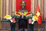 State President Luong Cuong (middle) presents congratulatory flowers to the two promoted officers (Photo: VNA)