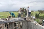 Soldiers and trainees from the Military School of Military Region 5 are pouring concrete pillars and constructing the second floor according to the design to provide shelter for residents during floods. (Photo: VNA)
