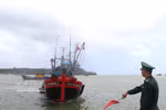 A border guard requests a fishing vessel to dock for verification of its entry and exit logs (Photo: VNA)