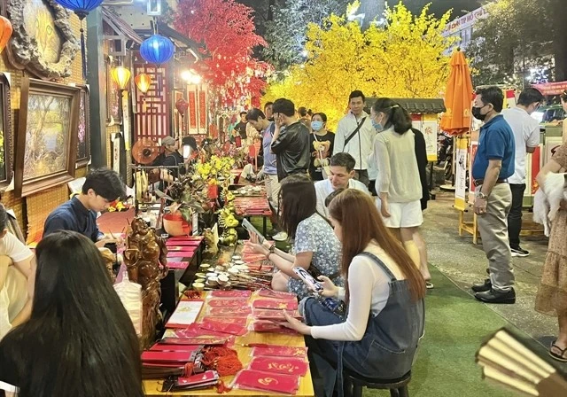 Local and international visitors exploring a Tet bazaar, a vibrant market featuring shops and stalls, during the Tet (Lunar New Year) 2025 festival in HCM City. (Photo: VNS/VNA)