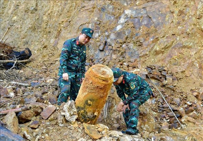 Military personnel work to remove the bomb. (Source: VNA)