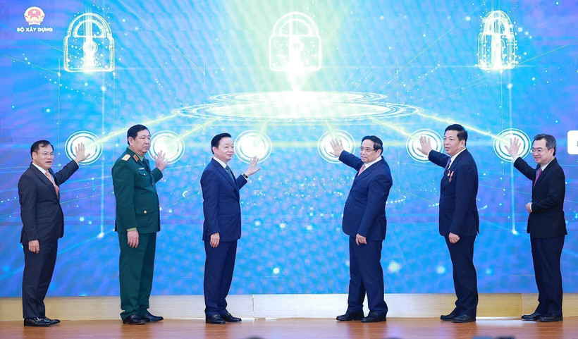 Prime Minister Pham Minh Chinh (third from right) and officials launch the Ministry of Construction’s new information technology systems at the conference on December 21. (Photo: VNA)
