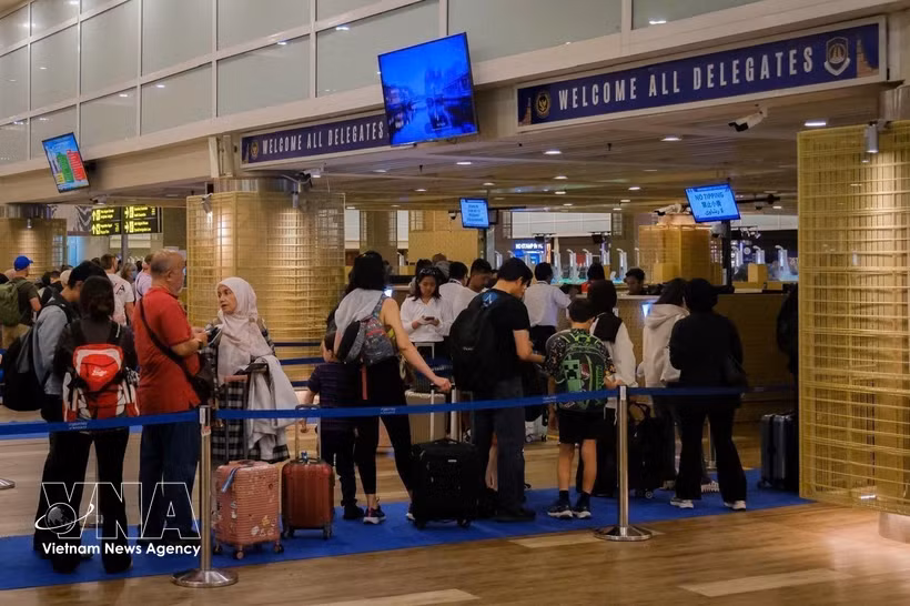 Passengers wait to handle procedures at Nugah Rai International Airport in Bali, Indonesia. (Photo: VNA)