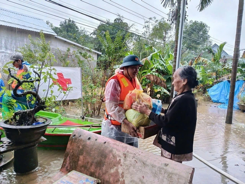 A representative of the Vietnam Red Cross Society delivers relief to a flood-hit resident in Hue city. (Photo: VNA)