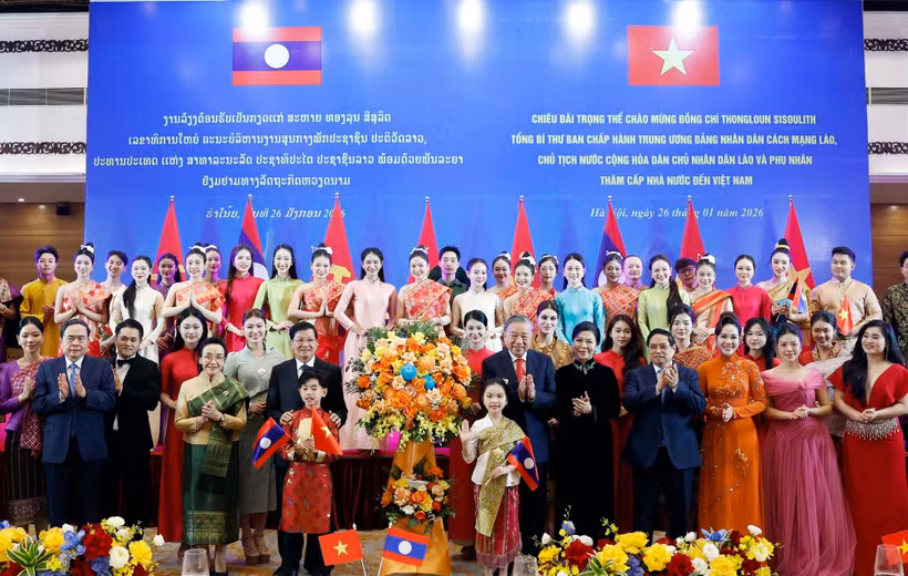 Party General Secretary To Lam and his spouse, together with Party General Secretary and President of Laos Thongloun Sisoulith and his spouse, present flowers to artists at the banquet. (Photo: VNA)