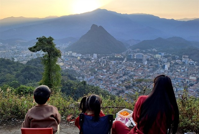 Tourists view the sunset over Ha Giang city from the Mo Neo Mountain. (Photo: VNA)
