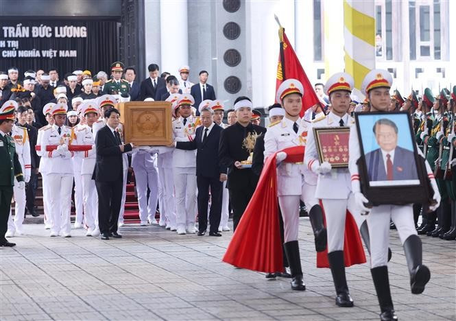 The portrait and coffin of former State President Tran Duc Luong are transferred to the hearse following the memorial service at the National Funeral Hall in Hanoi on May 25 morning. (Photo: VNA)