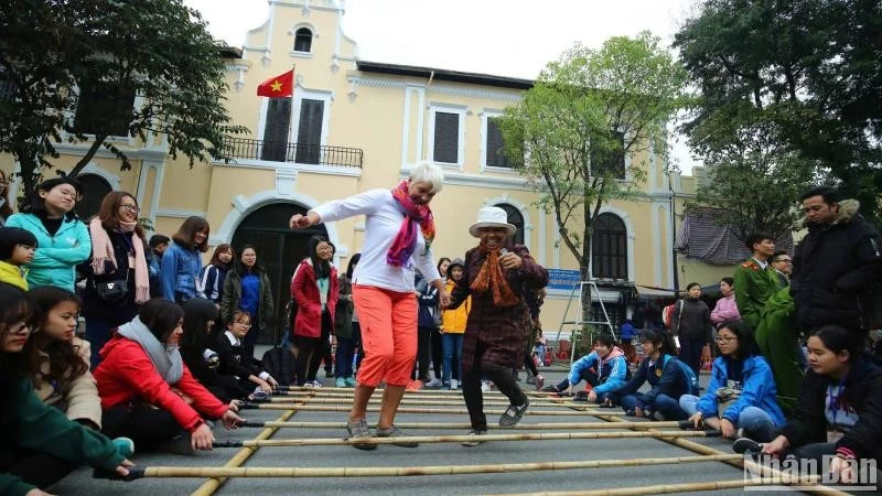 Foreign tourists enjoy a folk cultural activity in Hanoi (Photo: Nhan dan Newspaper)
