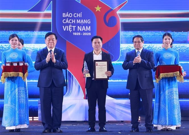 PM Pham Minh Chinh (second from right) and Chairman of the Party Central Committee's Commission for Information, Education and Mass Mobilisation Nguyen Trong Nghia (second from left) present an award to a representative of VietnamPlus reporters at the ceremony on June 21. (Photo: VNA)